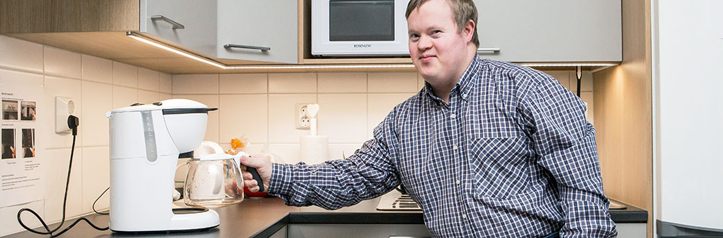 Man med Downs syndrom arbetar i ett kök