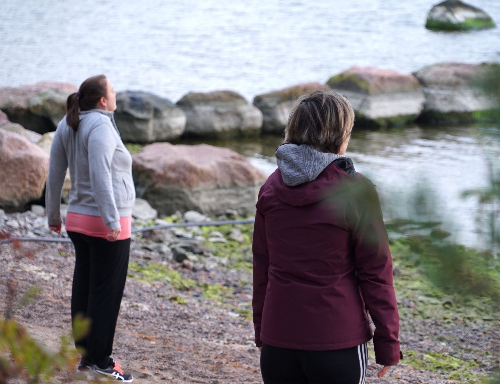Personer som gör mindfullnessövningar på en strand vid havet.