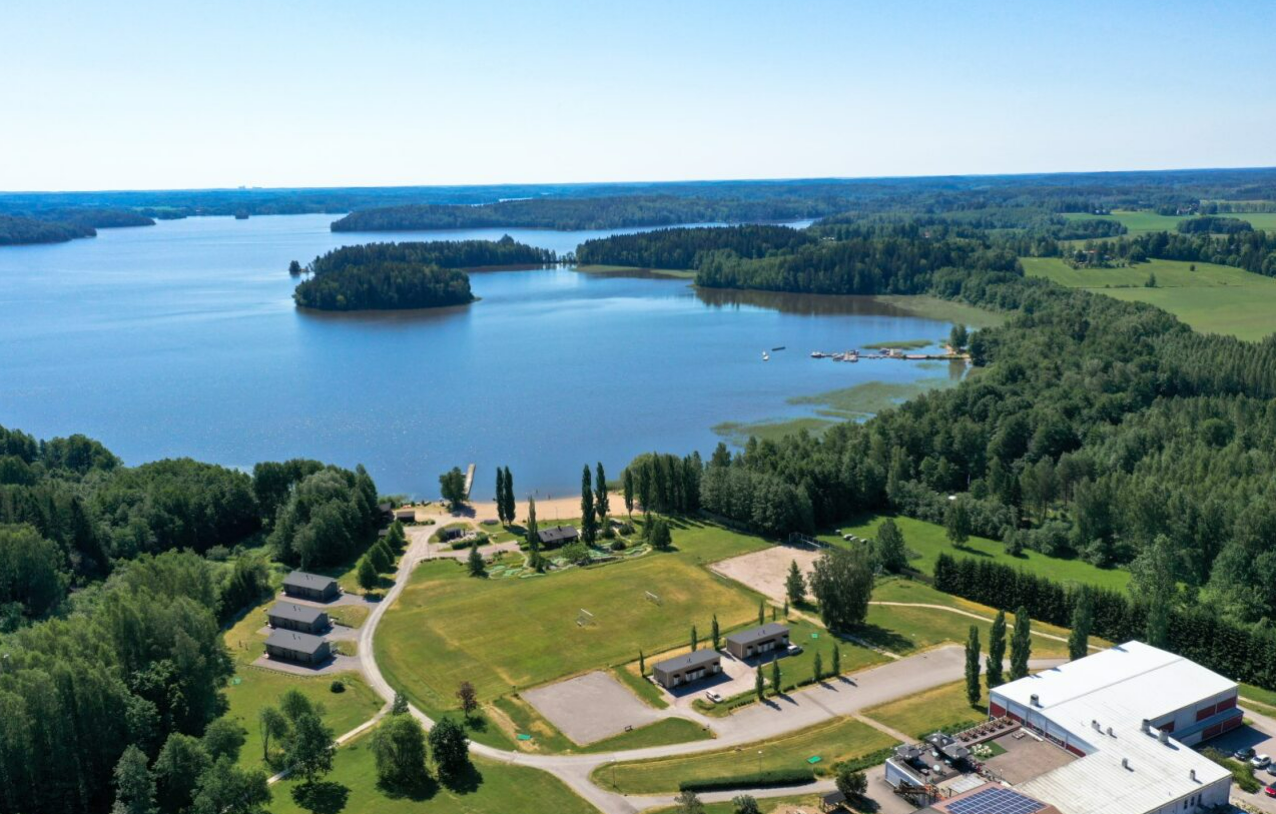 Lojo spa och resort invid en sjö och omringad av skog fotat uppifrån.