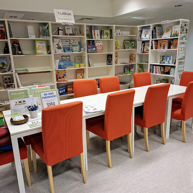 Bokhyllor och en länsstol i ett bibliotek.