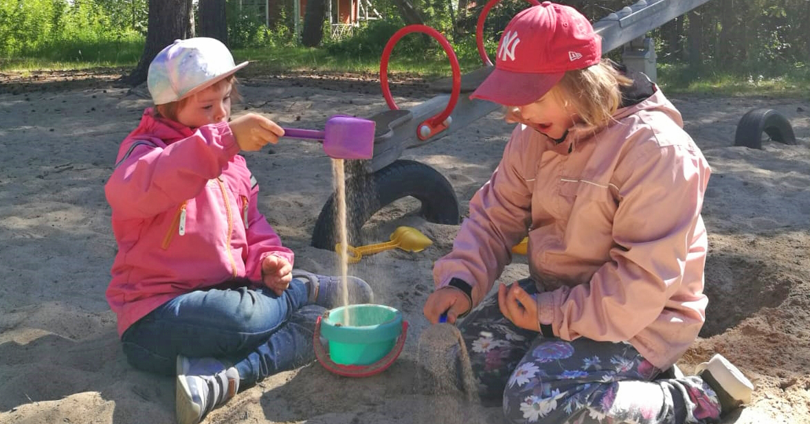 Två barn leker i sanden.