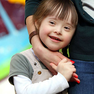 Flicka med downs syndrom håller kvinna i handen