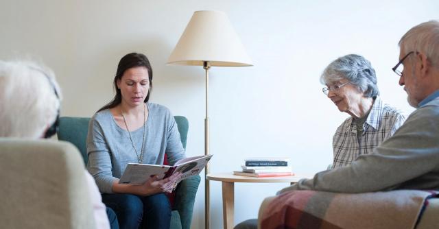 Kvinna läser högt till äldre personer