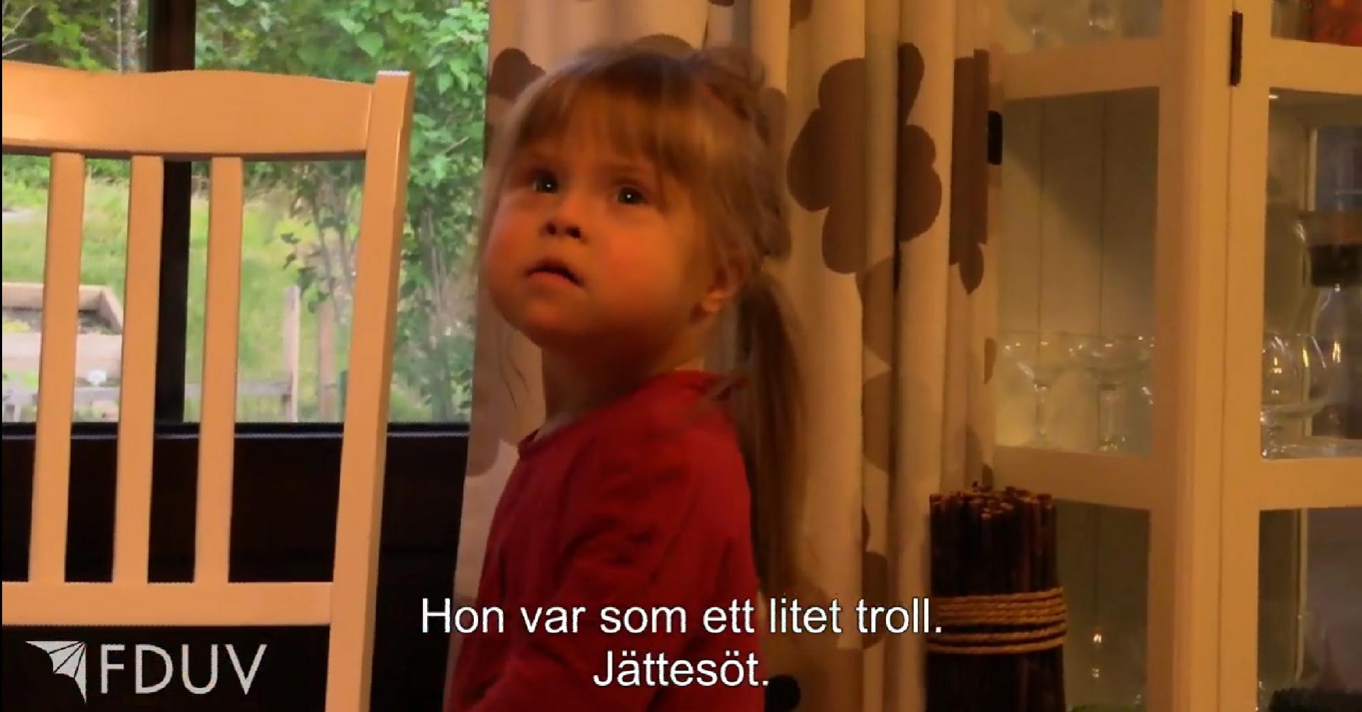 Skärmklipp från film. Bild på barn med downs syndrom och texten Hon var som ett litet troll. Jättesöt.