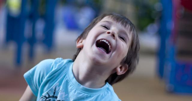 Ett barn gapskrattar.