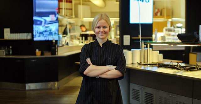 Catharina Stude står med armarna i kors i en lunchrestaurang.