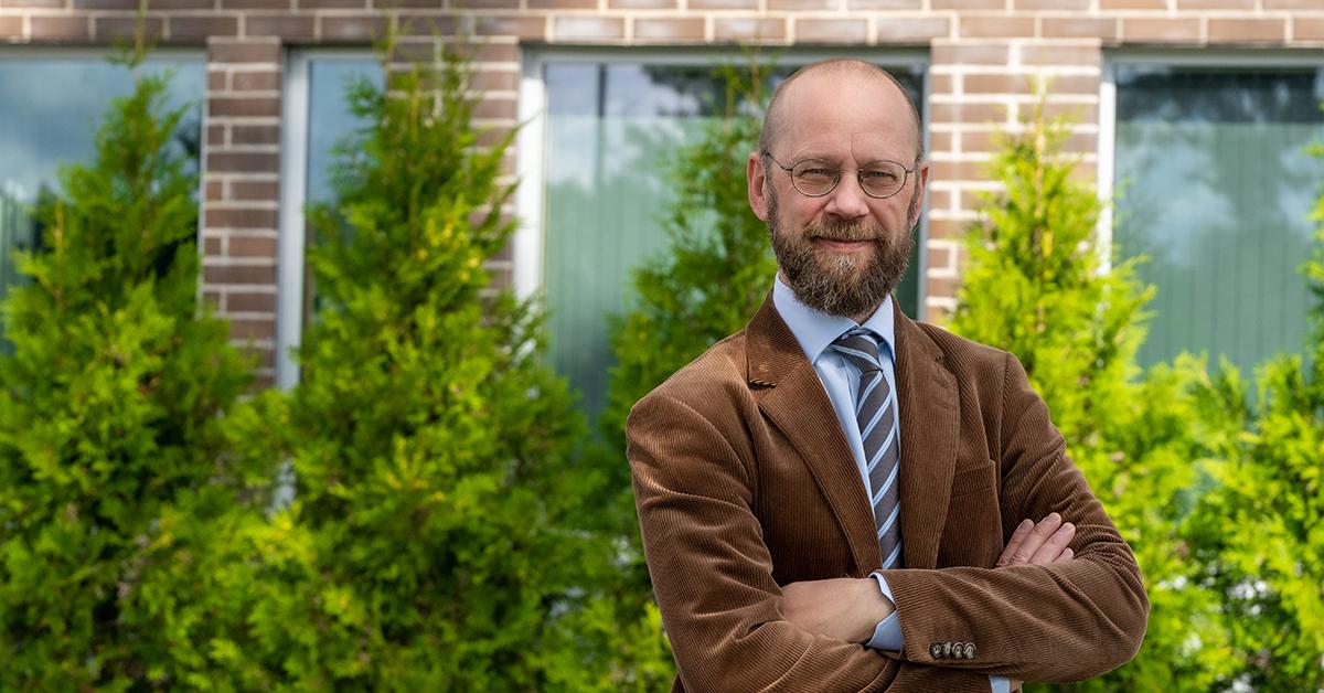 Leende Otto Ilmonen i brun sammetskostym.