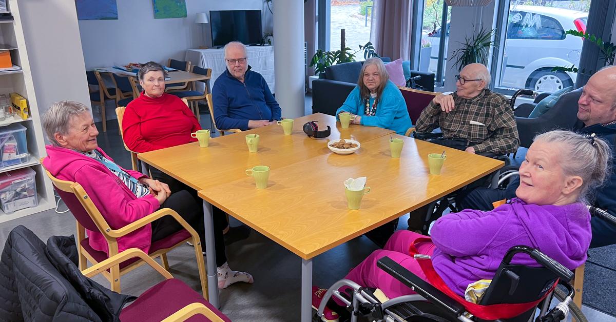 Flera personer varav några i rullstol sitter kring ett bord.