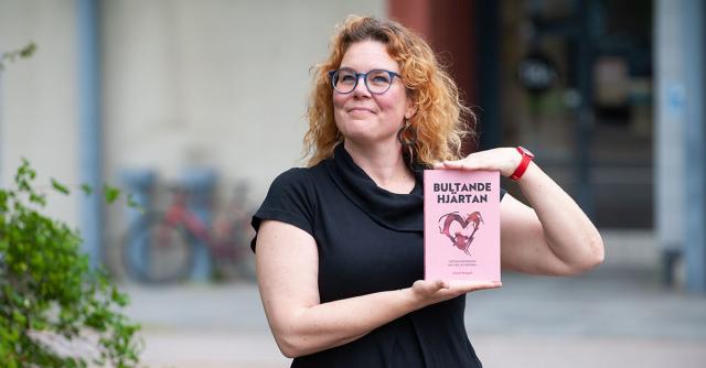Jolin SLotte håller stolt upp boken Bultande hjärtan.