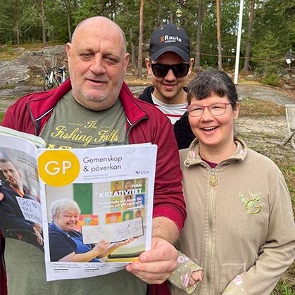 Tre personer som bläddrar i ett nummer av GP.